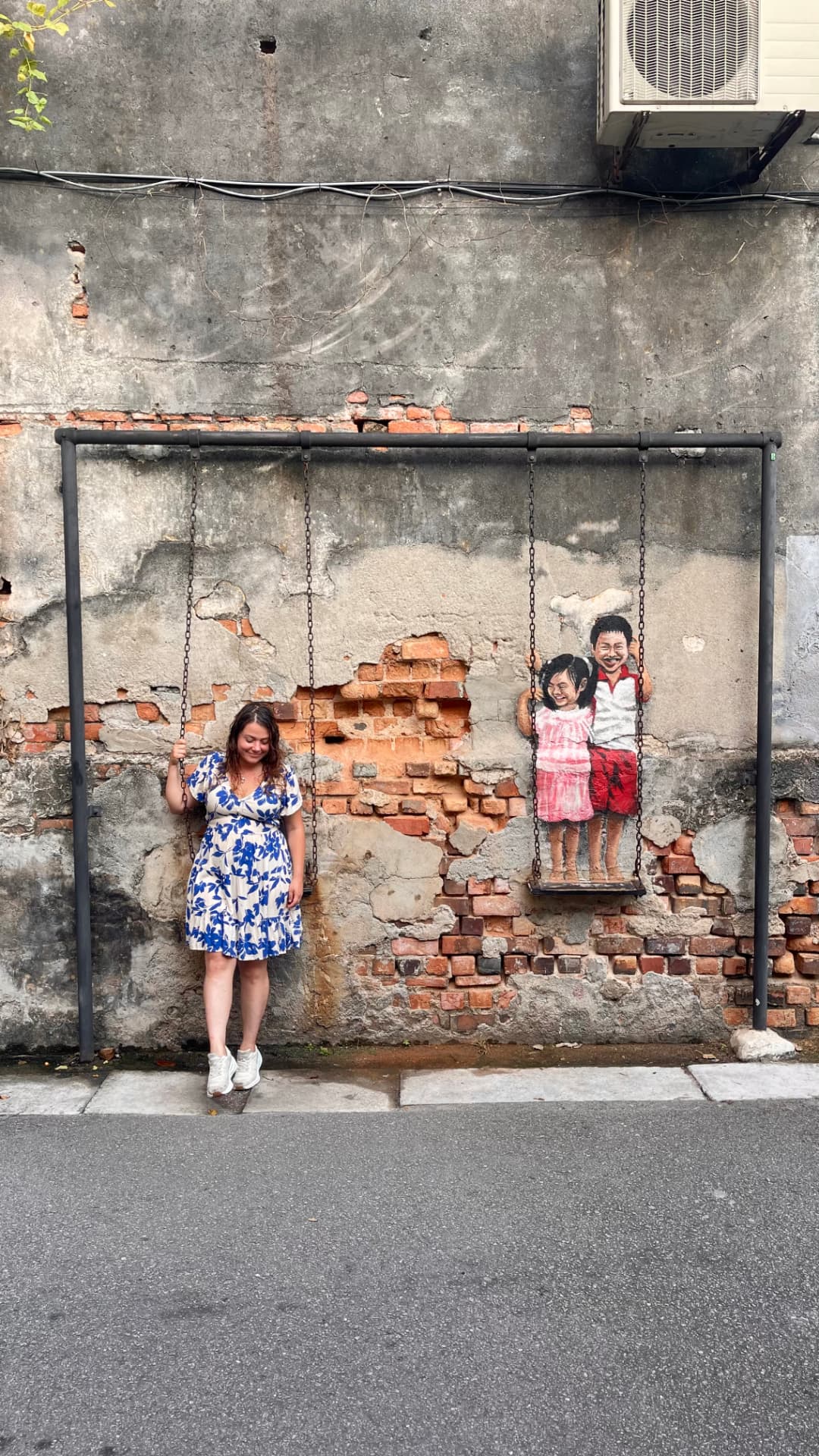 Justine devant une fresque représentant une balançoire