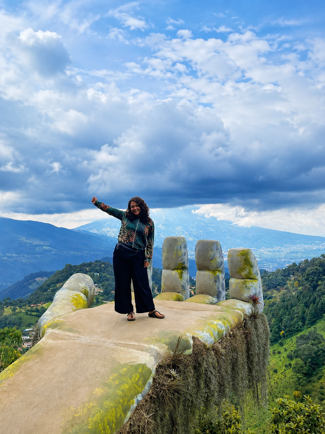 Justine sur une sculpture de main géante en montagne
